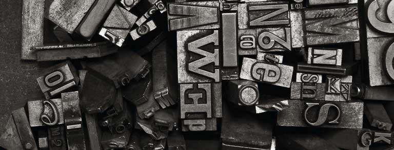 Graphic: A variety of metal type sorts for handset letterpress printing in a resorting tray.